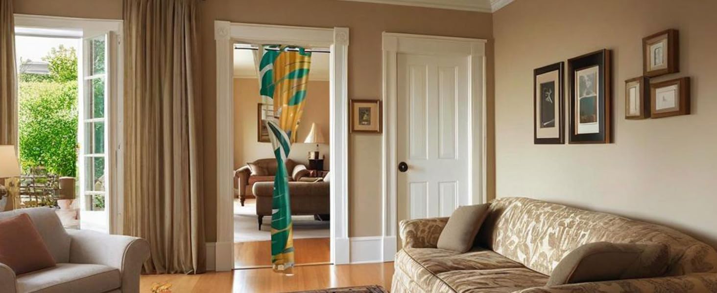Interior room view showing beige sofa, framed artwork, and tall doorway with natural light coming through windows.