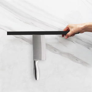 a hand holding a knife on a kitchen counter