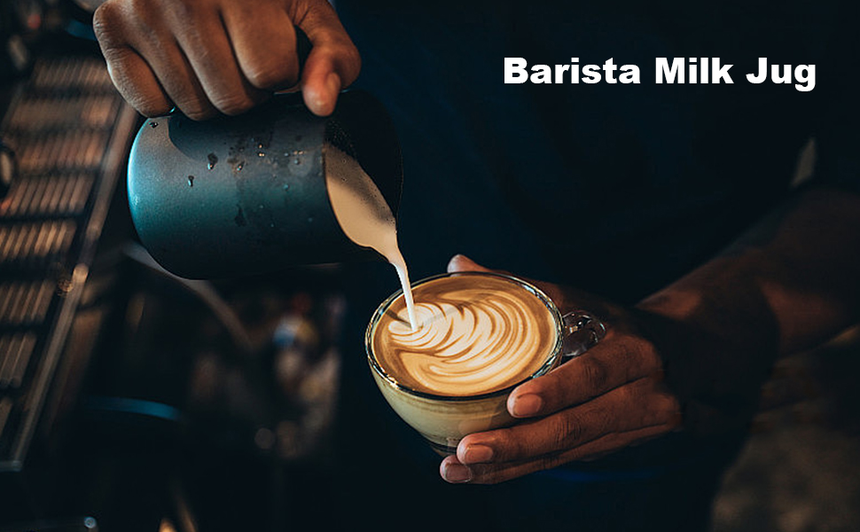Barista pouring steamed milk from a blue jug into a coffee cup, creating latte art. Dark, moody lighting emphasizes the pouring action.