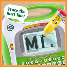 Letter M displays on screen with trace lines. Toy says, Trace the next line! Pencil traces line.