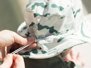 toddler boy wearing sage green checkers Tiny Twinkle Sun Hat