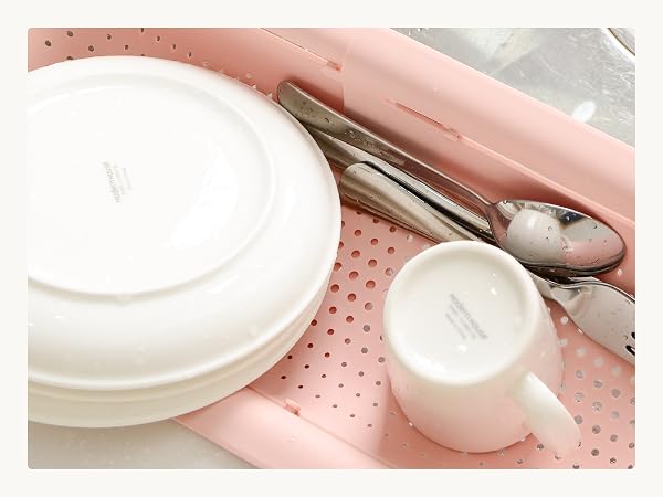 Dishes air-drying in sink colander after rinsing, not a full dish rack replacement