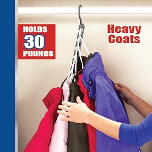 Hanging thick bulky jackets and coats on Wonder Hanger Max. She's smiling as she touches coats.