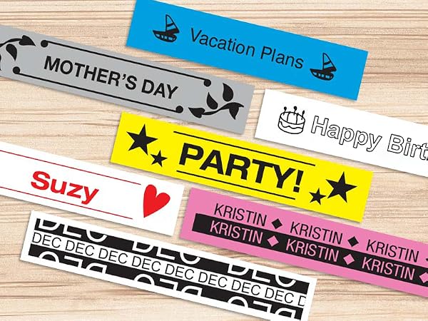 Different colored sample labels on a wood surface, with different fonts, symbols, and borders used