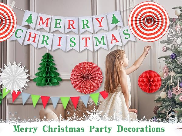 Christmas party decoration set featuring paper fans, trees, bells in red and green, with 'Merry Christmas' banner against grey wall.