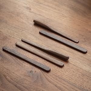 On the table are some coffee stirring sticks made of black walnut
