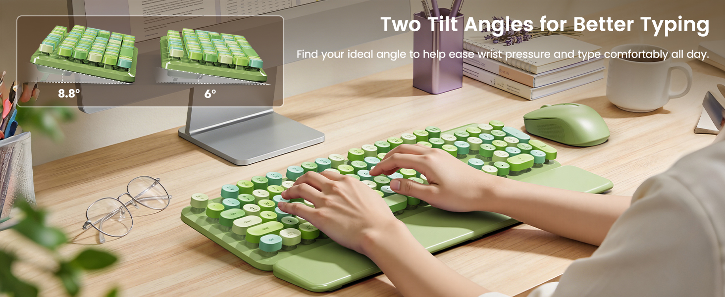 Hands typing on green keyboard with wrist rest, showing two adjustable tilt angles on desk