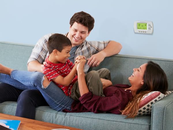Family playing in front of Wi-Fi 7-Day Programmable Thermostat
