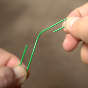 A person bending paper clip to show how strong paper clip is.