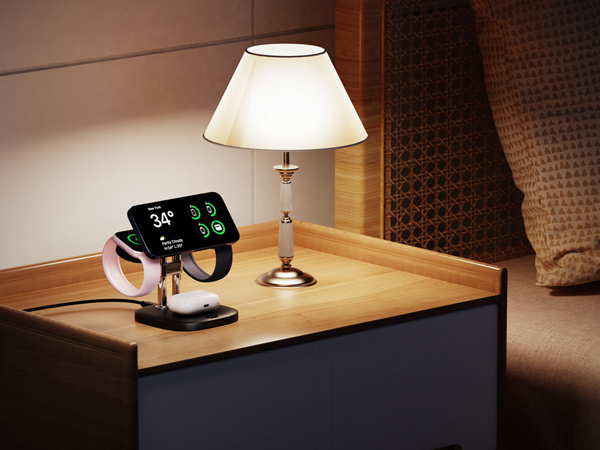 Bedside table with lamp and digital alarm clock displaying time and temperature. Dark room setting suggests nighttime use.