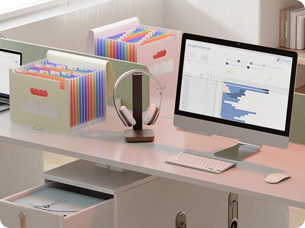 Modern desk setup with computer monitors, keyboard, and colorful expanding file organizers arranged neatly on a white desk surface.