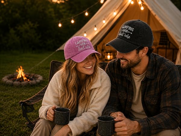Couple at sunset campsite wearing embroidered Camping baseball caps near campfire and canvas tent