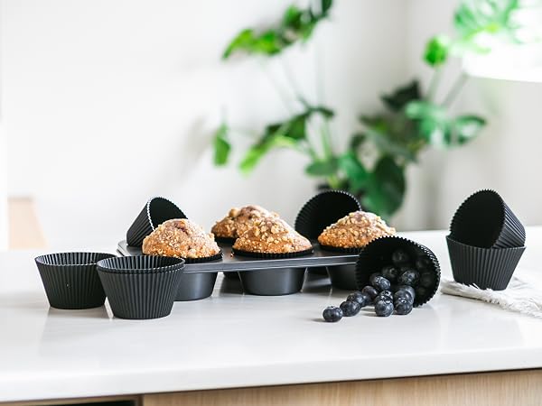 Matte black silicone baking cups with muffins and blueberries