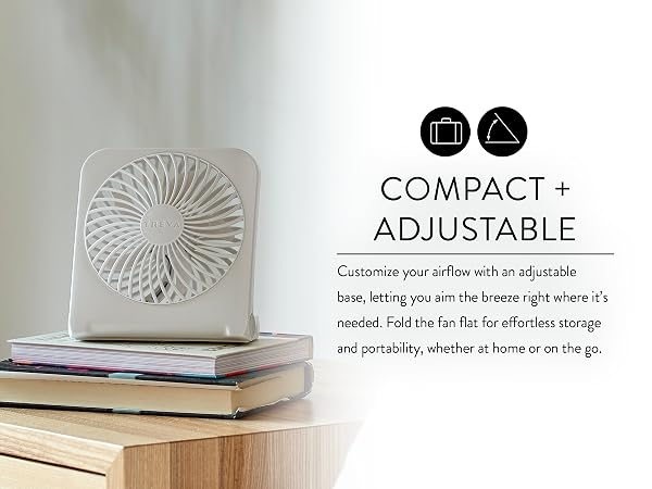 White Treva USB rechargeable fan on side table on stack of books