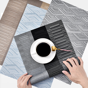 a person's hands holding a coffee cup on a table.