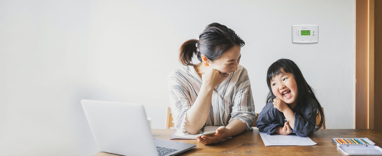 Mom and daughter sitting in front of the 5-2 Day Programmable Thermostat