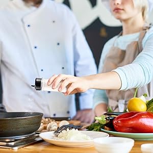 Chef adding salt to dish