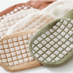 Three round exfoliating bath sponges in beige and light green colors. Textured surface with a waffle-like pattern visible.