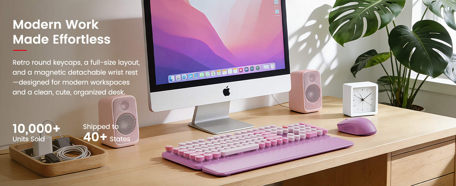Lavender purple wireless keyboard and mouse with magnetic wrist rest on tidy desk beside Computer.
