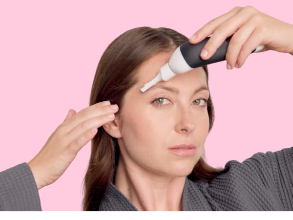Woman using face trimmer