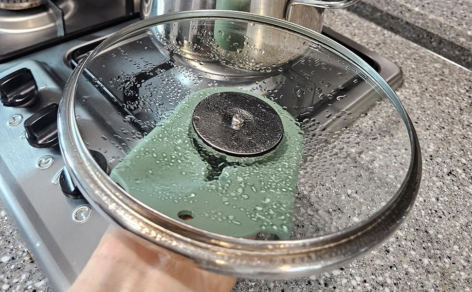 Pot lid with water droplets resting on silicone lid holder on kitchen countertop