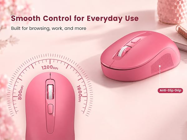 Pink wireless mouse with DPI switch and anti-slip side grip shown on a soft pink desktop.