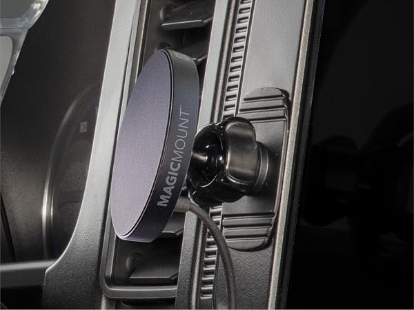Dashboard cell phone holder with adhesive base MagSafe car mount charger sits near vehicle controls
