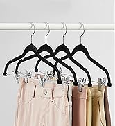 Four black plastic hangers on a white rod, holding pastel-colored pants. Hangers feature clips for secure garment attachment.
