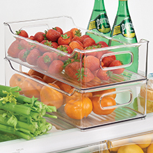 clear stacked bins with handles on fridge shelf holding clementines, strawberries, celery, bottles