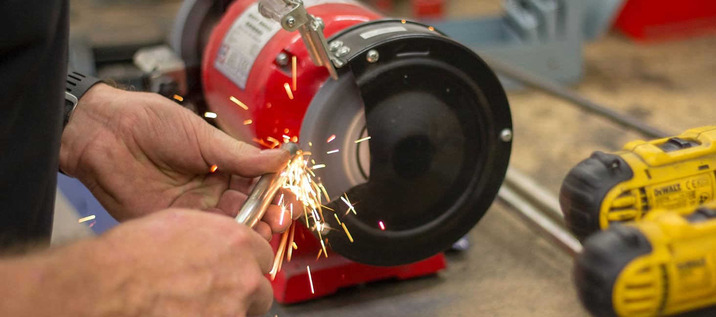 a man uses a grinder to cut a piece of metal.