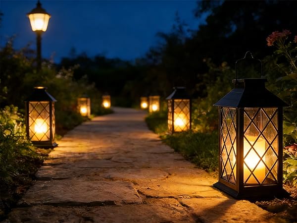 Evening pathway lit by traditional lanterns placed along both sides, creating atmospheric lighting against darkening sky.