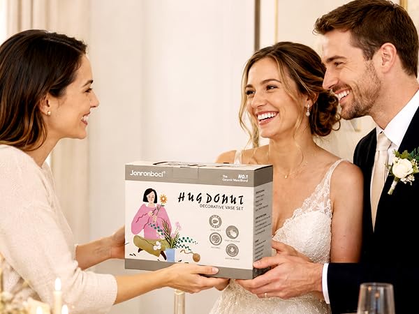 Woman gives vase gift box to bride and groom