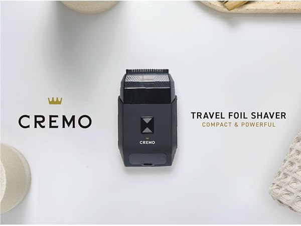 Cremo Travel Foil Shaver displayed with brand logo and grooming accessories