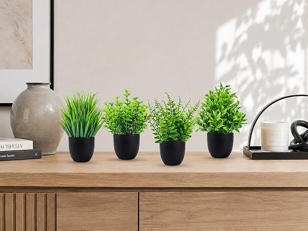 four artificial green plants black pots tabletop display