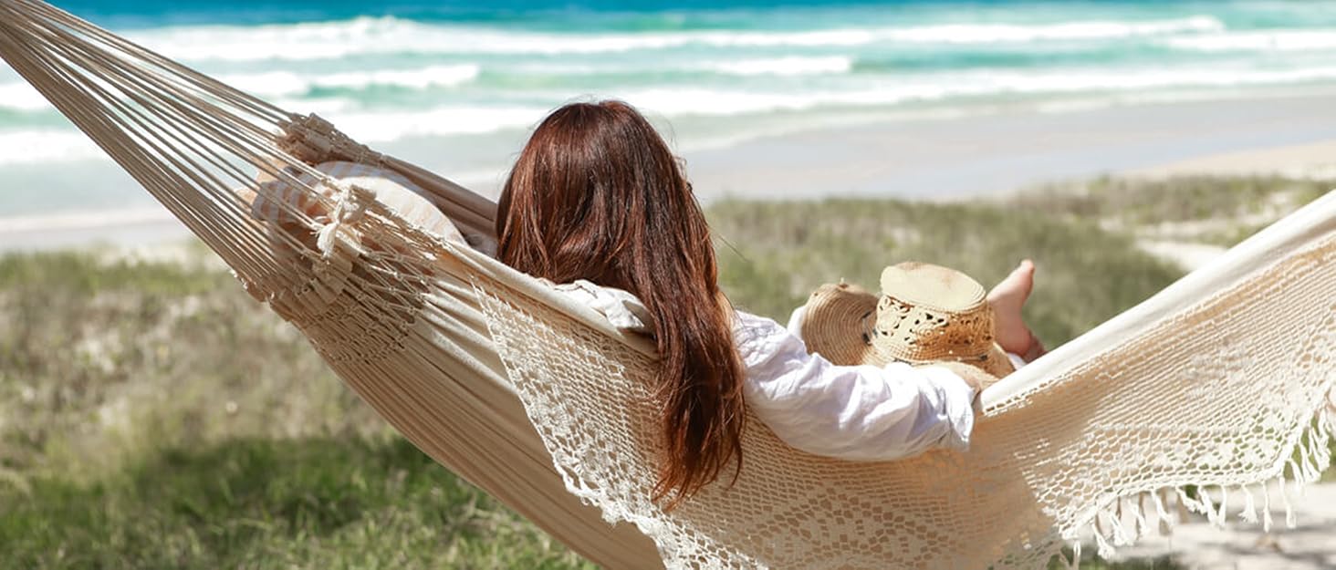 Woman in natural hammock with fringe on beach