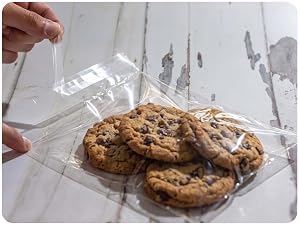 Hand smoothing a clear Pack It Chic cello bag over freshly baked cookies