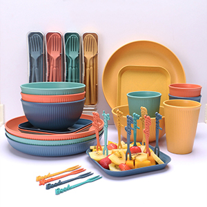 Colorful outdoor dining set with plates, bowls, cups, and utensils in coral, teal, yellow, and navy blue colors, arranged in stacked display.