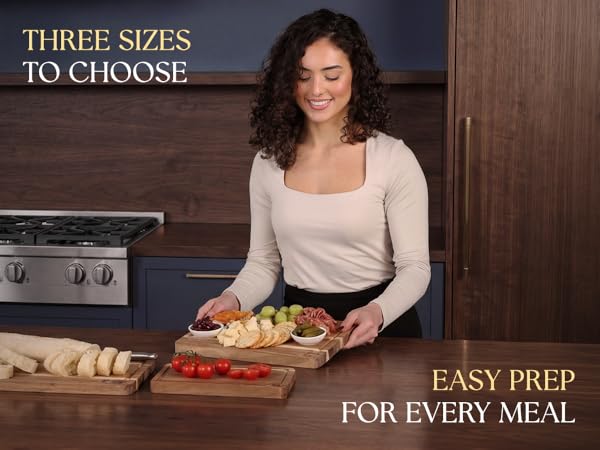 Three Acacia cutting boards with bread and food prep on kitchen counter.