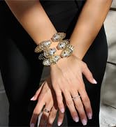 Close-up of a wrist wearing multiple colorful beaded bracelets. Hand rests on dark fabric, possibly clothing.