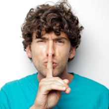 man hushing with finger to represent unpleasant toilet noises