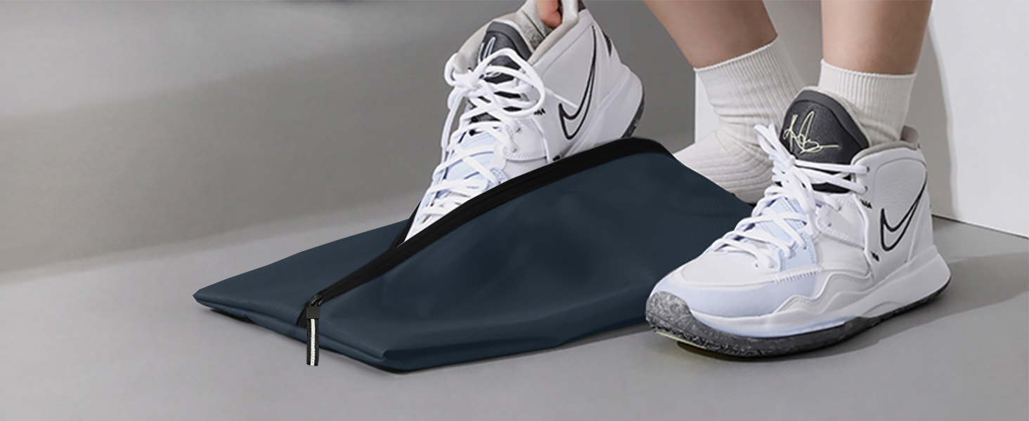 Dark blue or black compression sleeve or wrap shown with white Nike athletic shoes, demonstrating wear or application on lower leg.