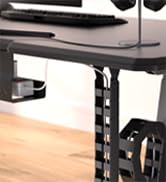 Close-up of a standing desk's height adjustment mechanism. Black metal frame with a crank handle visible, indicating manual height control.