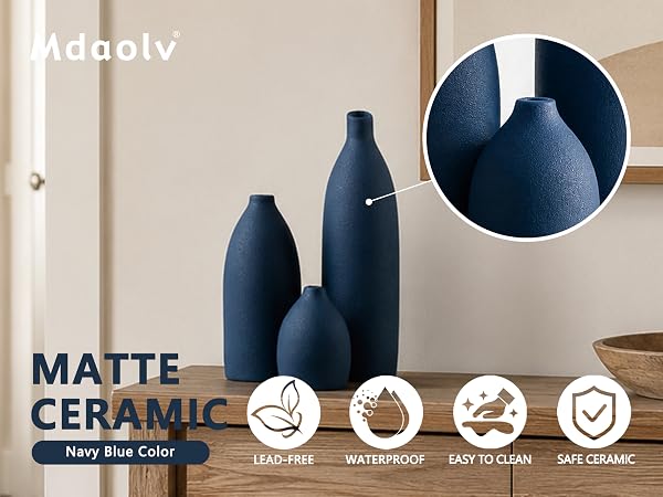 Matte navy blue ceramic vase set with textured finish displayed on a wooden console table