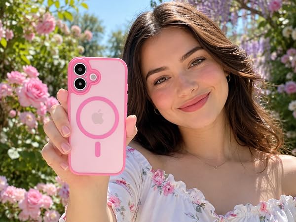 Young woman holding pink smartphone with magnetic ring attachment against floral background, demonstrating phone case with integrated MagSafe-style circular magnetic feature.