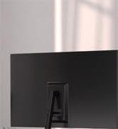 Back view of a slim, black rectangular electronic device, likely a TV or monitor, standing on a reflective surface against a light-colored wall.