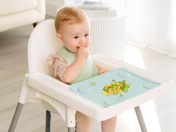 Baby eating in high chair with Prep silicone placemat keeping food organized during mealtime