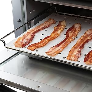 bacon cooking on toaster oven paper liners inside toaster