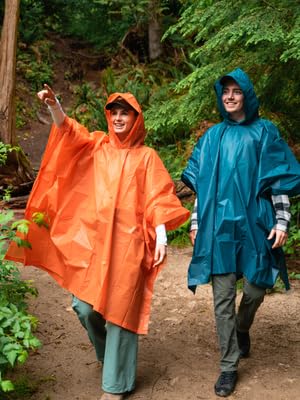 Coghlans Orange and Blue ponchos in forest, hiker