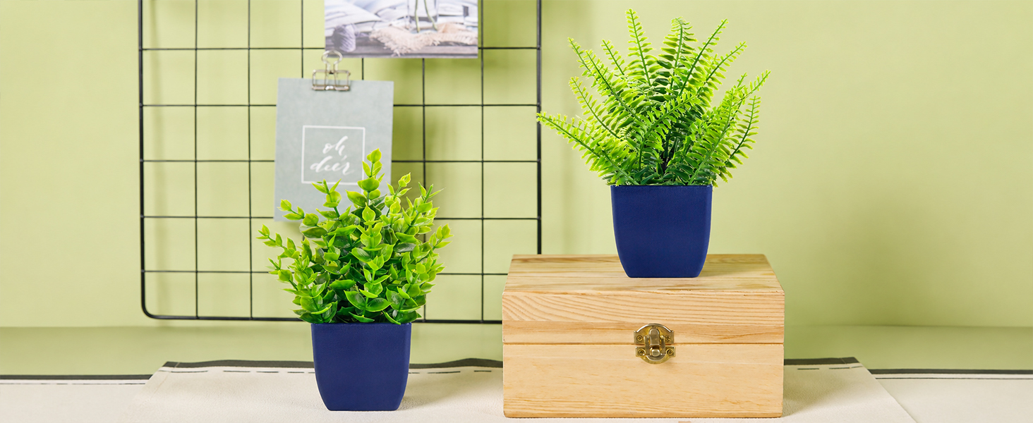 two artificial green plants blue pots tabletop decor