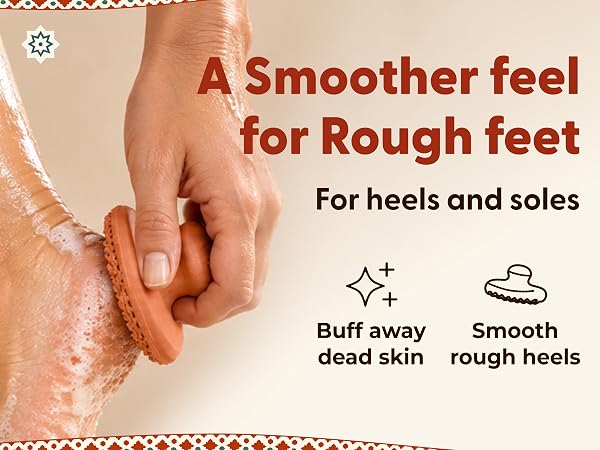 A hand uses a terracotta foot exfoliator on a wet, soapy heel